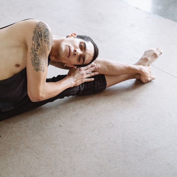 Focused man in a controlled pose improving his flexibility.