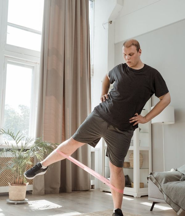 Man performing a strength and balance exercise at home.